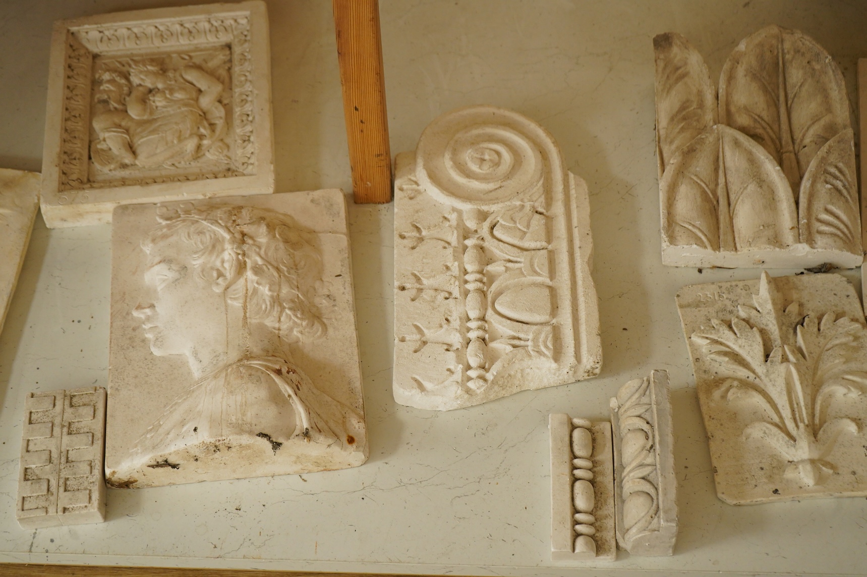 A collection of plaster-cast relief panels to include classical busts and foliage, largest 47cm high